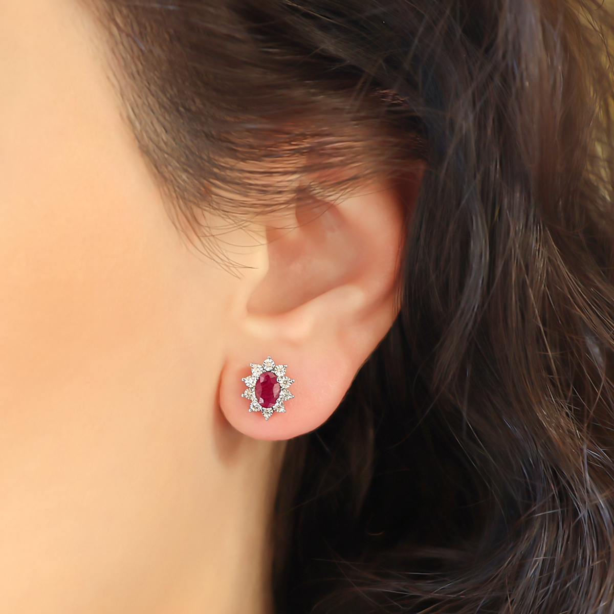 Model wears 9ct White Gold Oval Ruby & Diamond Cluster Stud Earrings