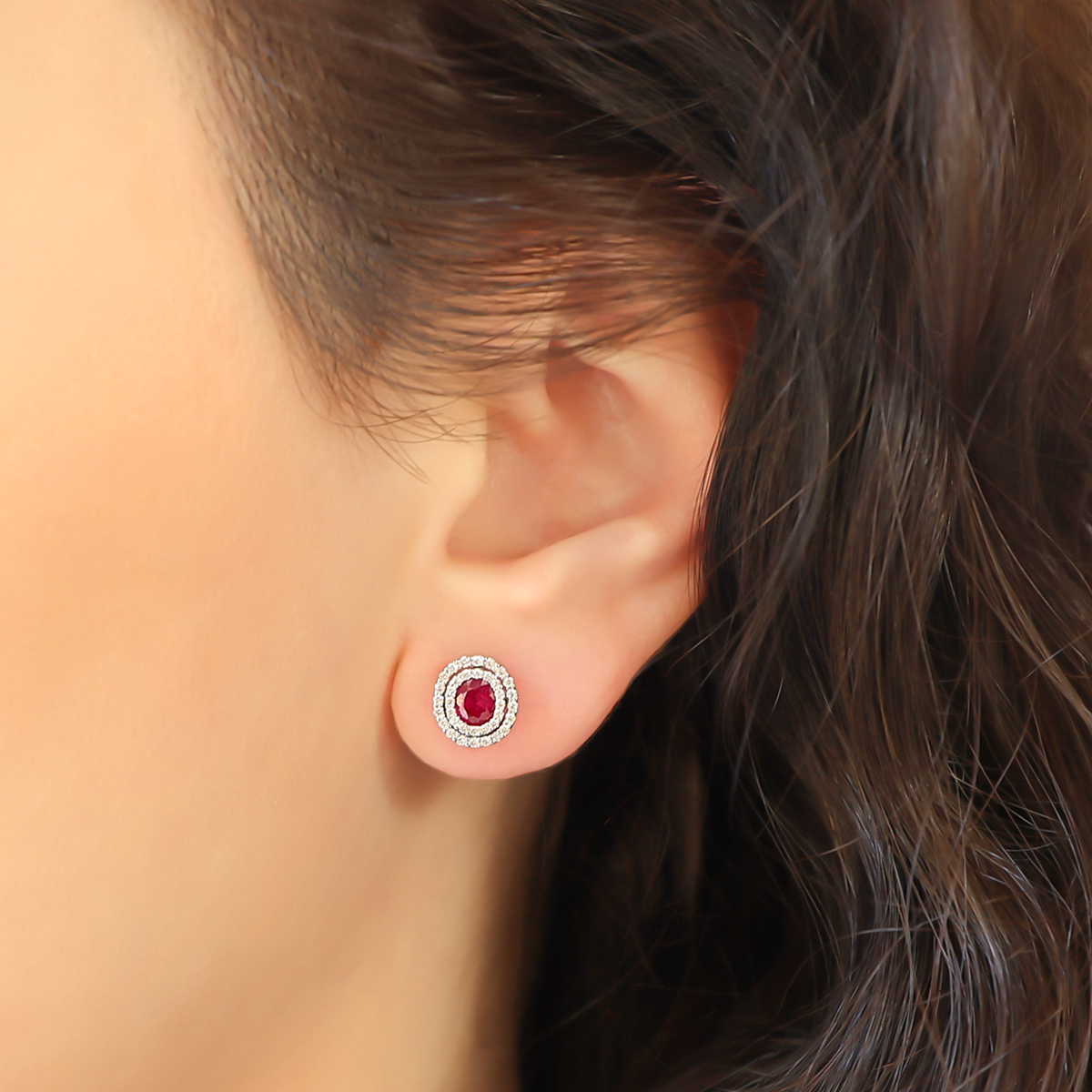 Model wears 9ct White Gold Oval Ruby & Diamond Double Halo Stud Earrings