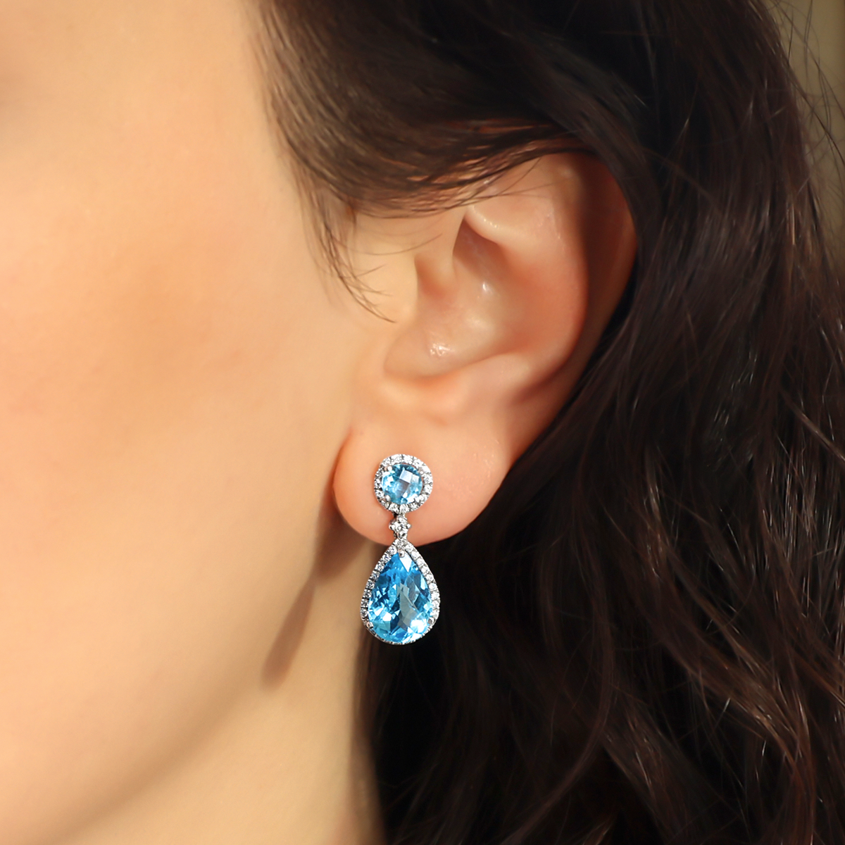 Model wears 18ct White Gold Blue Topaz & Diamond Halo Drop Earrings