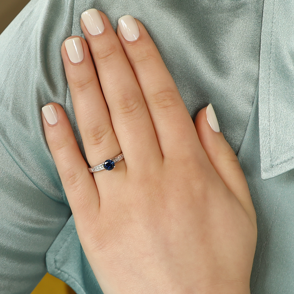 Model wears 18ct White Gold Sapphire & Diamond Channel Set Shoulders Solitaire Ring
