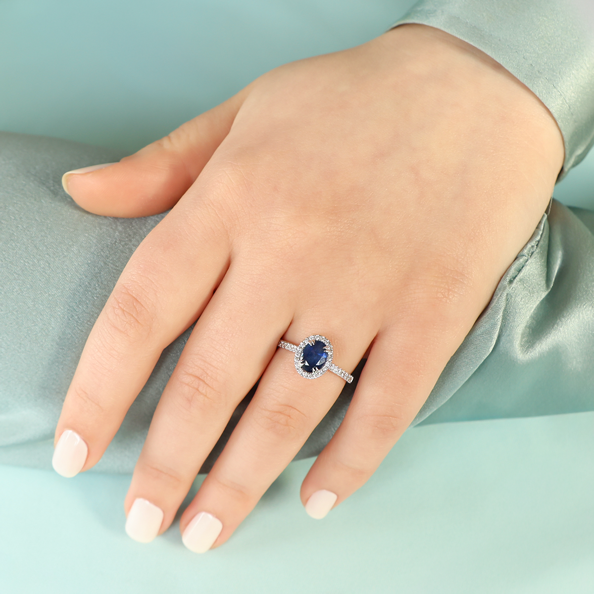 Model wears 18ct White Gold Oval Cut Sapphire & Diamond Halo Ring