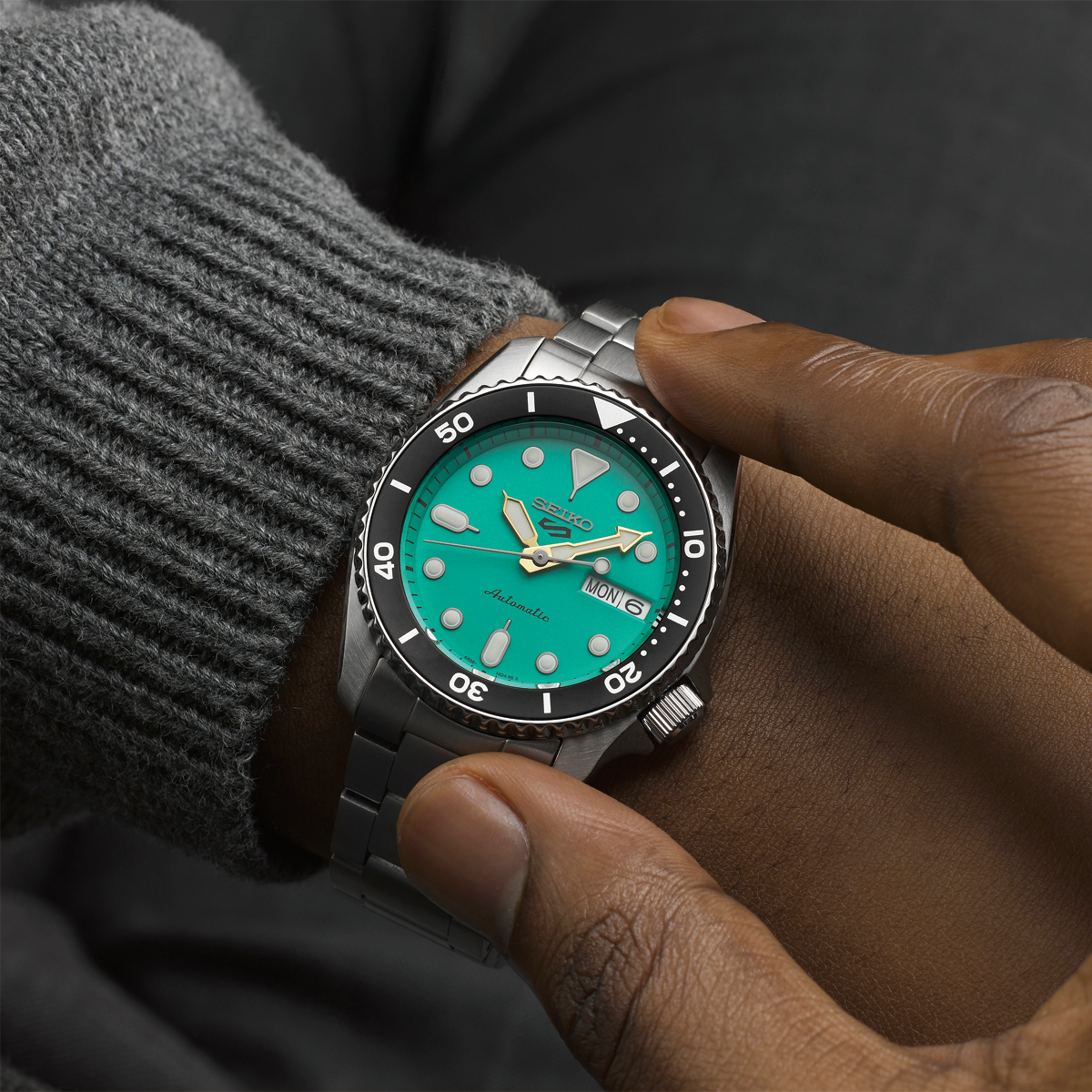 Model wears Seiko 5 Sports SKX “Midi”, Teal Dial With Stainless Steel Bracelet - SRPK33K1