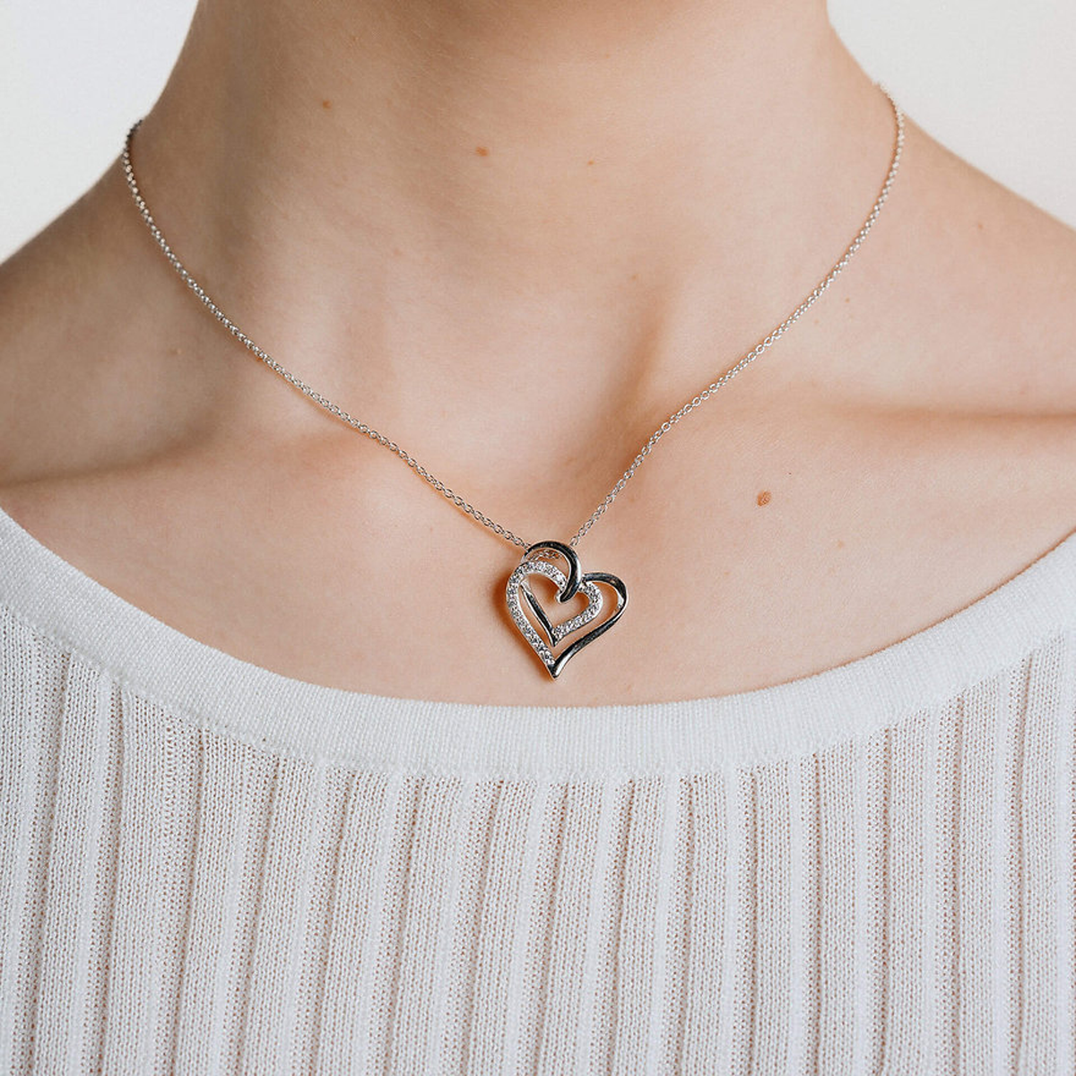 Model wears Sterling Silver Interlocking Hearts Cubic Zirconia Set Necklace