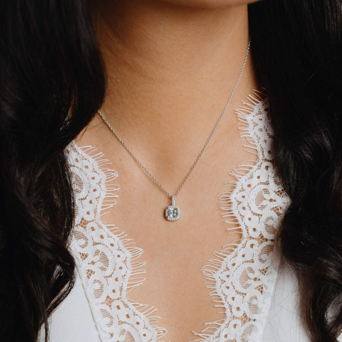 Model wears Sterling Silver Cushion Cubic Zirconia Halo Pendant & Chain