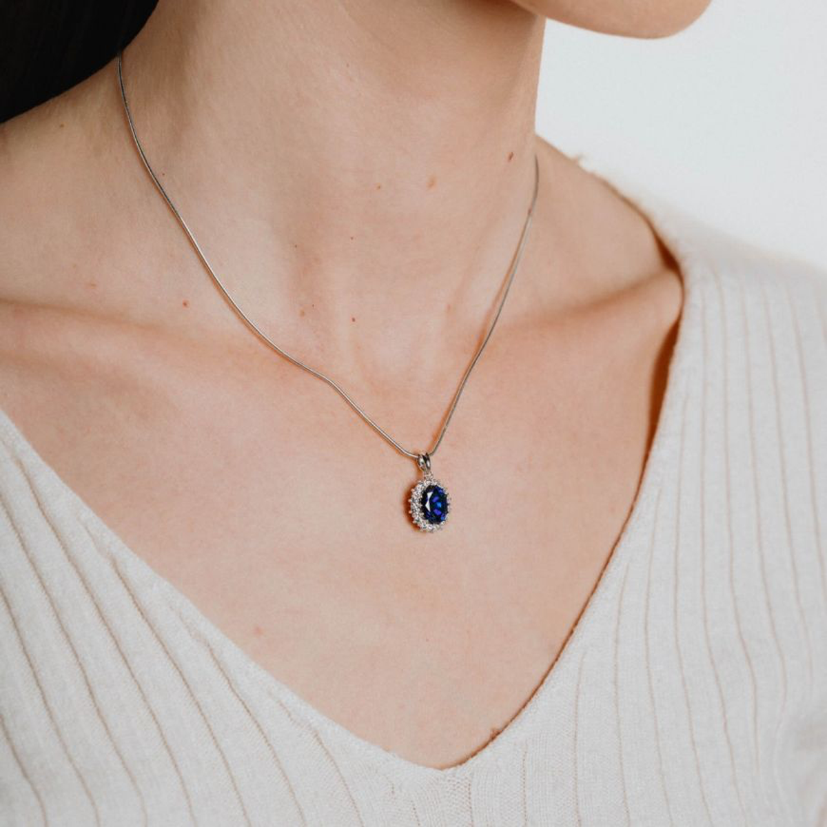 Model wears Sterling Silver Oval Shaped Blue Cubic Zirconia Cluster Pendant & Chain