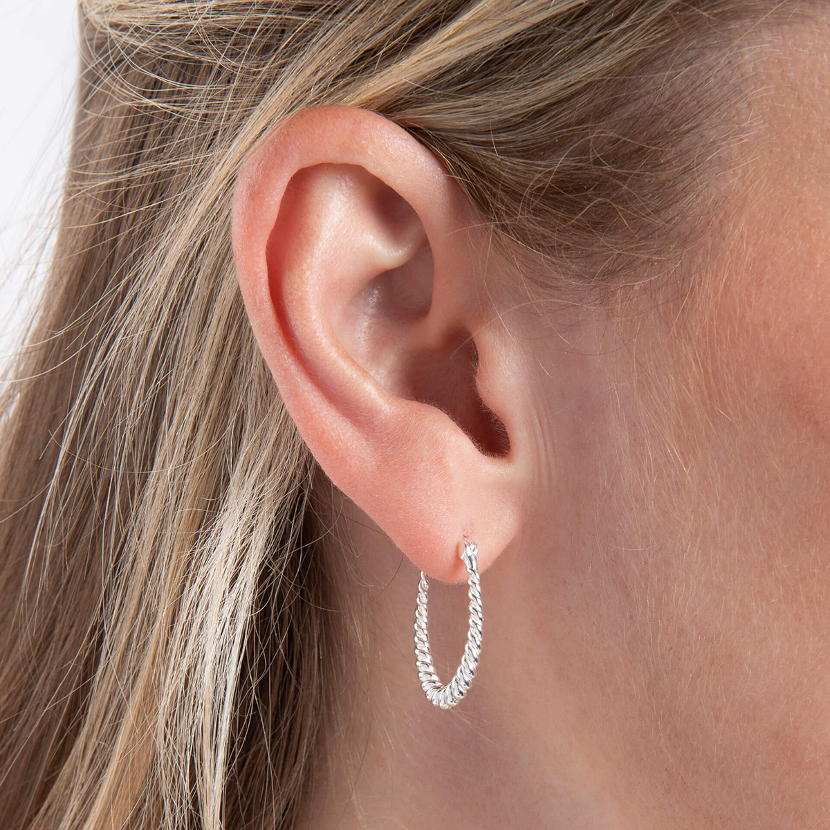 Model wears Sterling Silver Twisted Oval Hoop Earrings