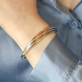 Model wears 9ct Three Colour Gold Entwined Hinged Bangle