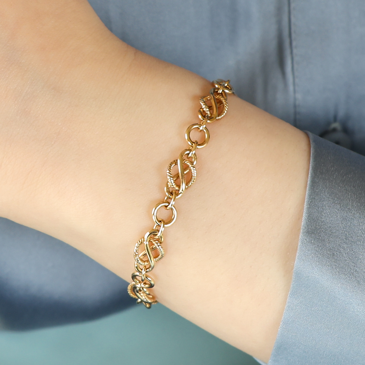 Model wears 9ct Yellow Gold Twisted Circle Infinity Link Bracelet