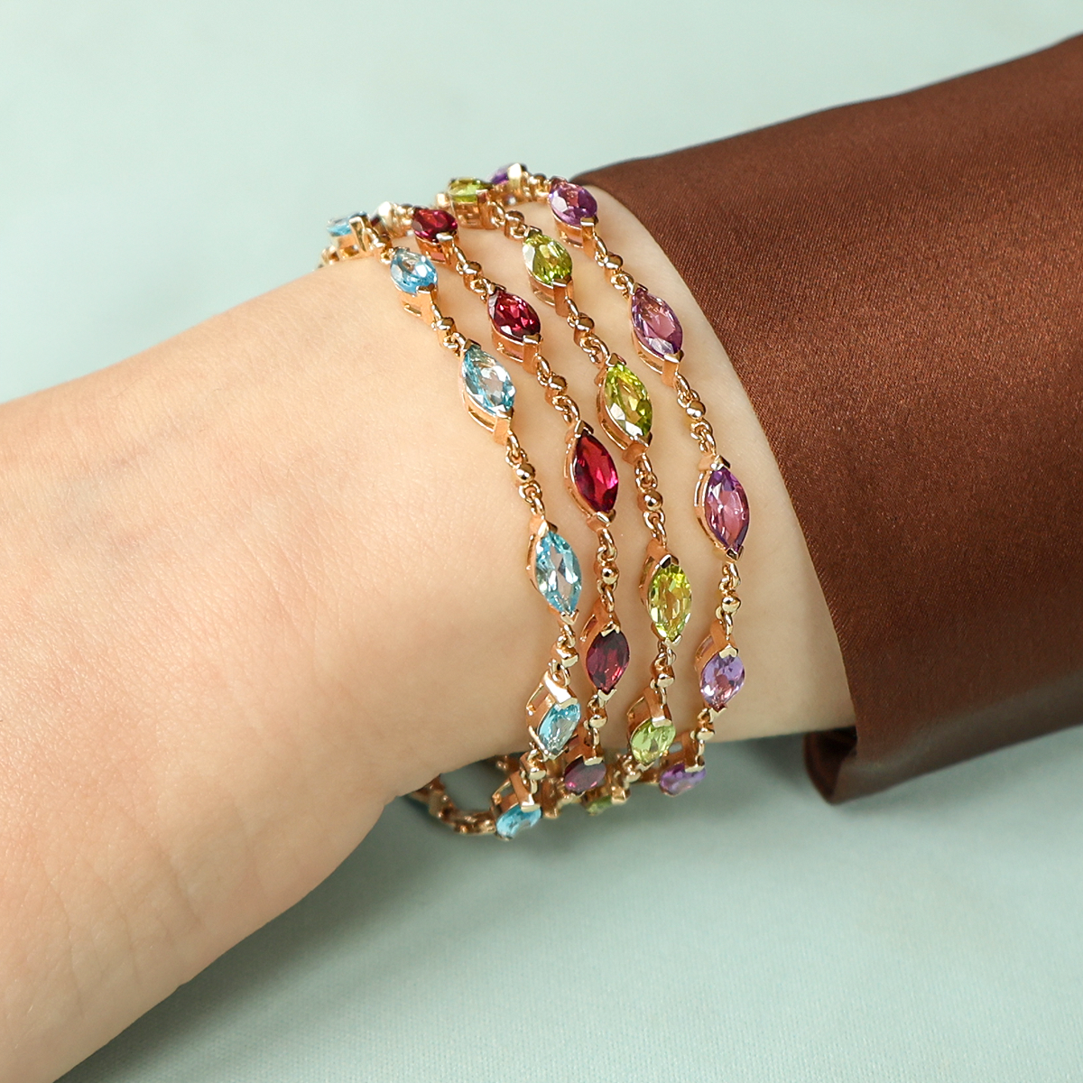 Model wears 9ct Yellow Gold Marquise Shaped Blue Topaz, Rhodolite Garnet, Peridot & Amethyst Bracelets