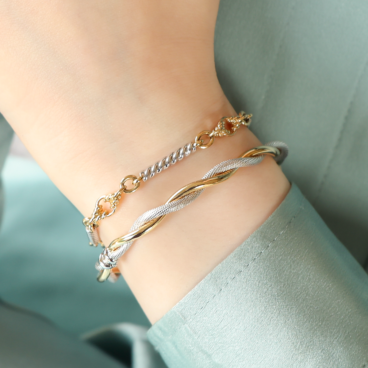 Model wears 9ct Yellow & White Gold Twisted Bar & Lover’s Knot Link Bracelet & 9ct Two Colour Gold Plain & Patterned Double Twist Tension Bangle