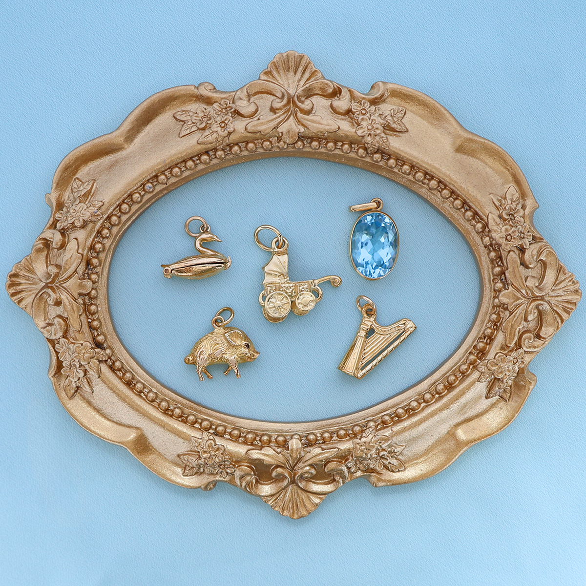 9ct Yellow Gold Swan Lake with Enamel Opening Charm, 9ct Yellow Gold Small Pig With Ruby Eyes Charm, 9ct Yellow Gold Small Moveable Pram Charm, 9ct Yellow Gold Large Oval Shaped Sky Blue Topaz Bezel Set Pendant, 9ct Yellow Gold Small Harp Charm