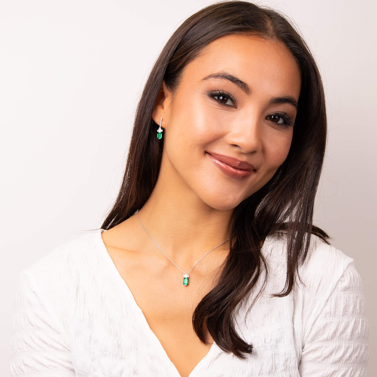 Model wears Sterling Silver Emerald Cut Green Cubic Zirconia Drop Pendant & Earrings
