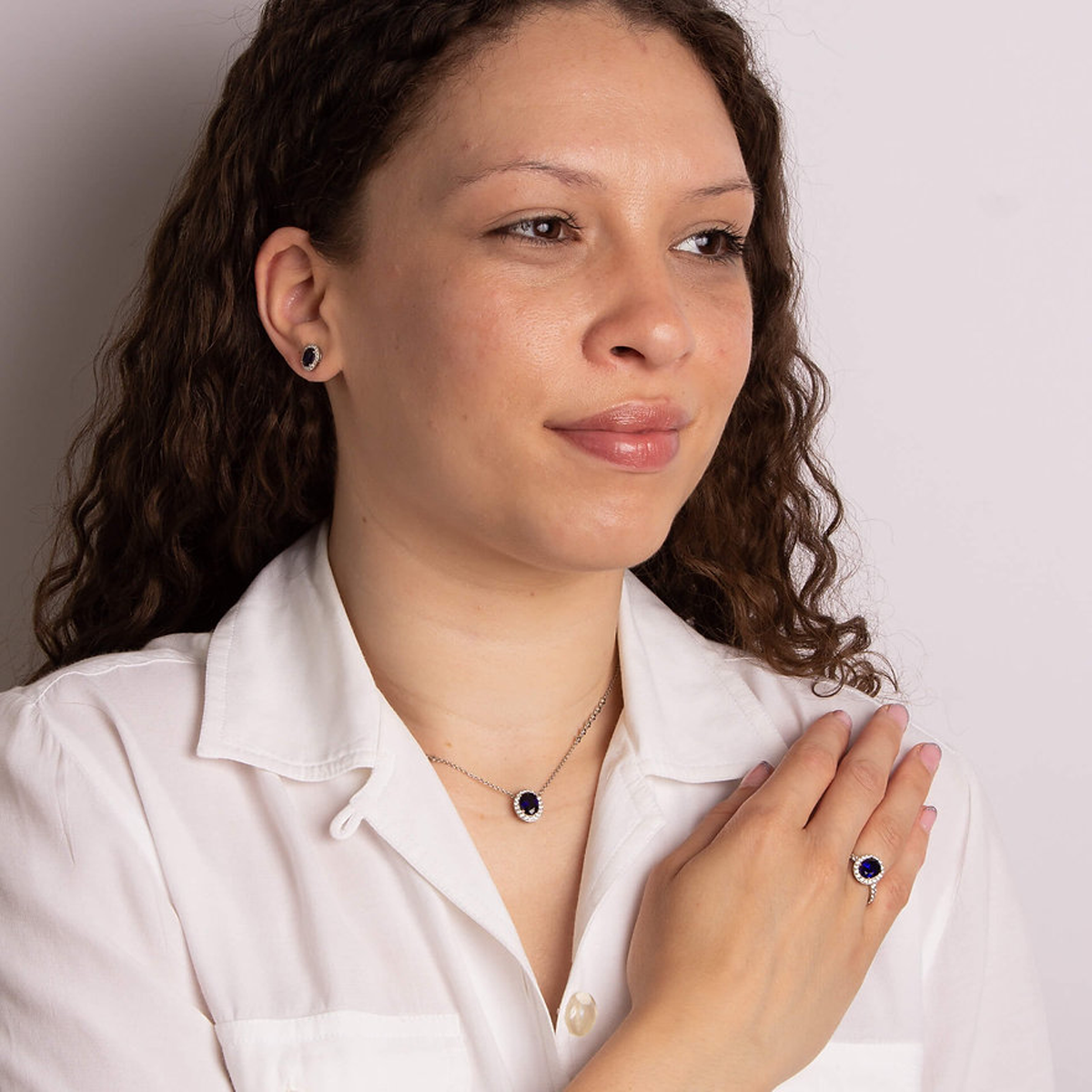 Model wears Sterling Silver Oval Blue Cubic Zirconia Halo & Shoulders Ring, Earrings & Necklace