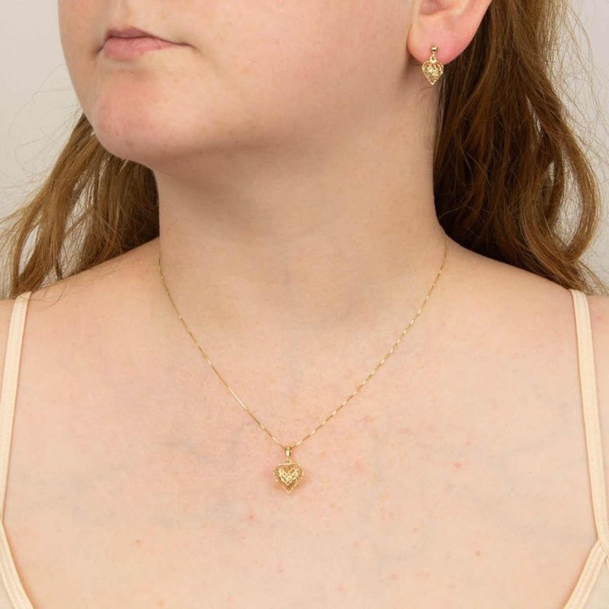 Model wears 9ct Yellow Gold Caged Heart Drop Earrings & Necklace