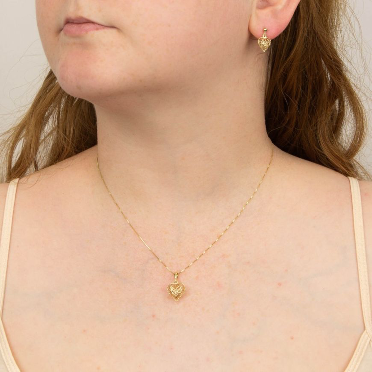 Model wears 9ct Yellow Gold Caged Heart Pendant & Earrings