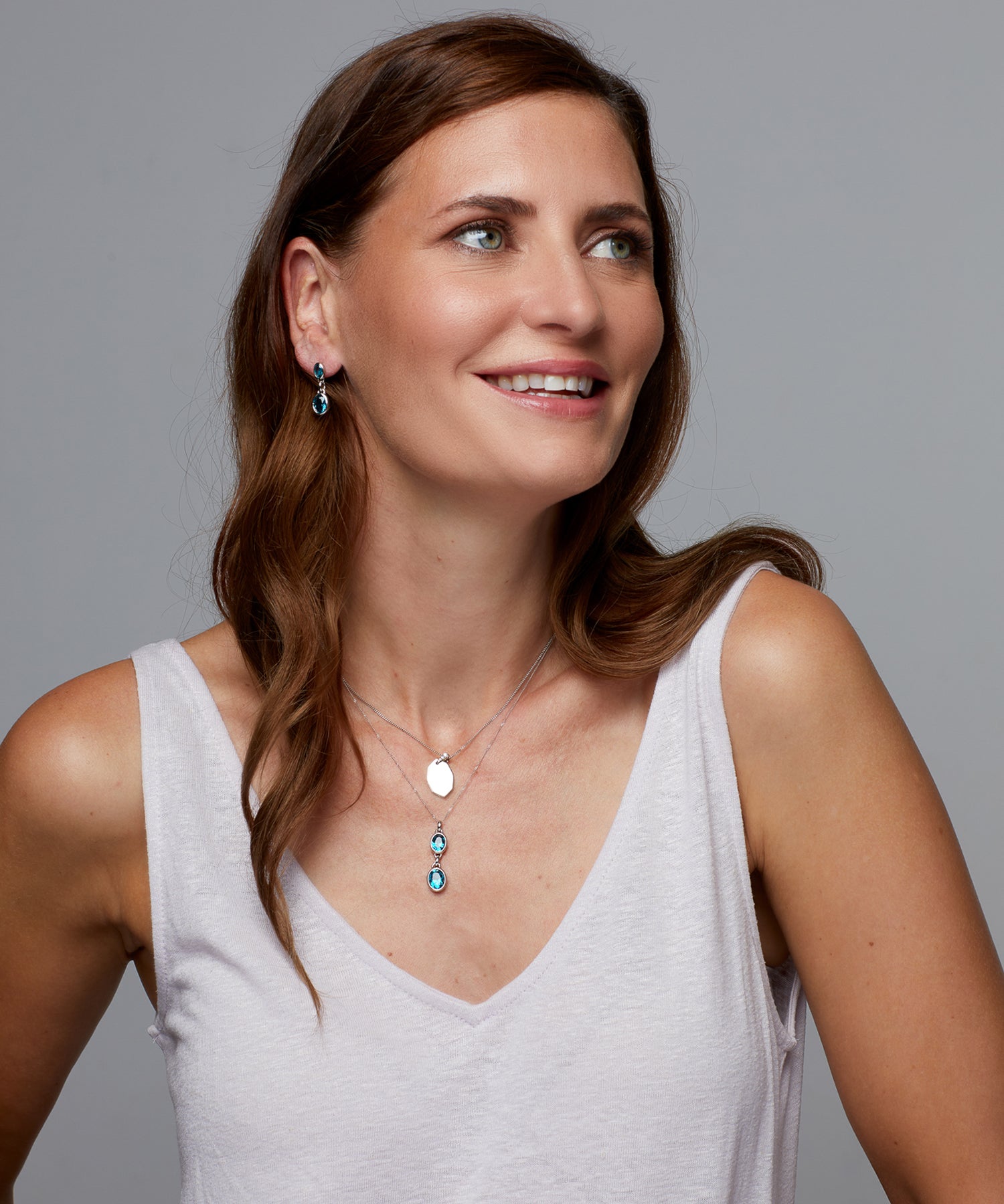 Female model wearing matching silver aqua nano crystal drop earrings and necklace. 