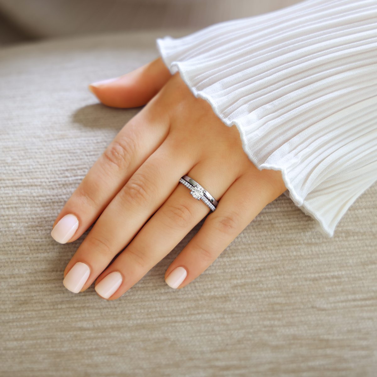 Model wears Platinum Round Brilliant Cut Diamond Solitaire & Shoulder 0.74ctw Ring with Wedding Band