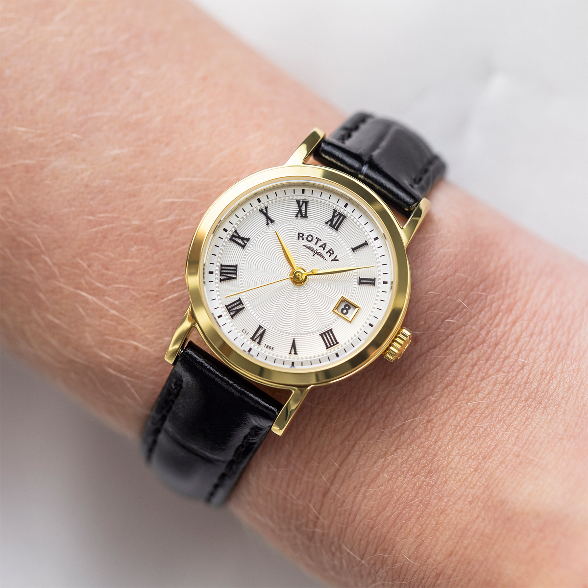 Model wears Rotary Heritage Ladies Gold Plated Watch, White Dial with Black Leather Strap - LS05423/01