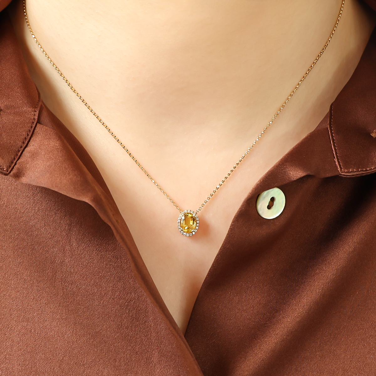 Model wears 18ct Yellow Gold Oval Shaped Yellow Sapphire & Diamond Halo Pendant with Chain