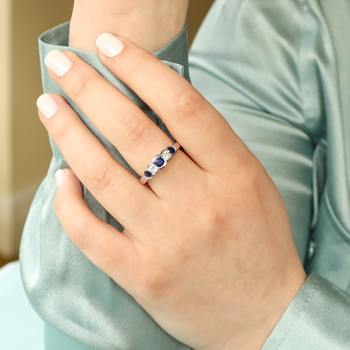 Model wears 9ct White Gold Sapphire & Diamond Bezel Set Five Stone Ring