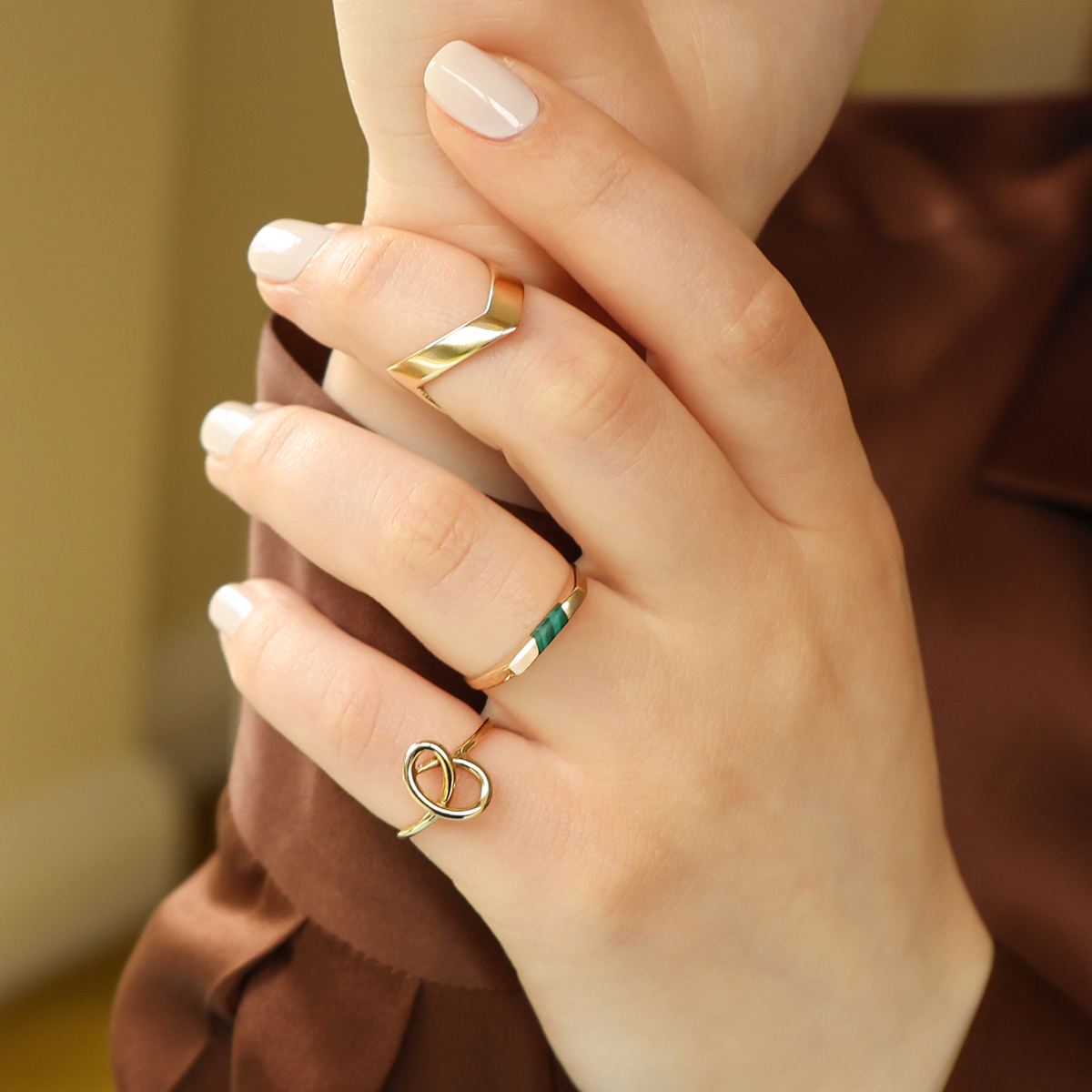Model wears 9ct Yellow Gold Plain Double Wishbone Ring, 9ct Yellow Gold Malachite Horizontal Rectangle Signet Ring & 9ct Yellow Gold Love Knot Ring