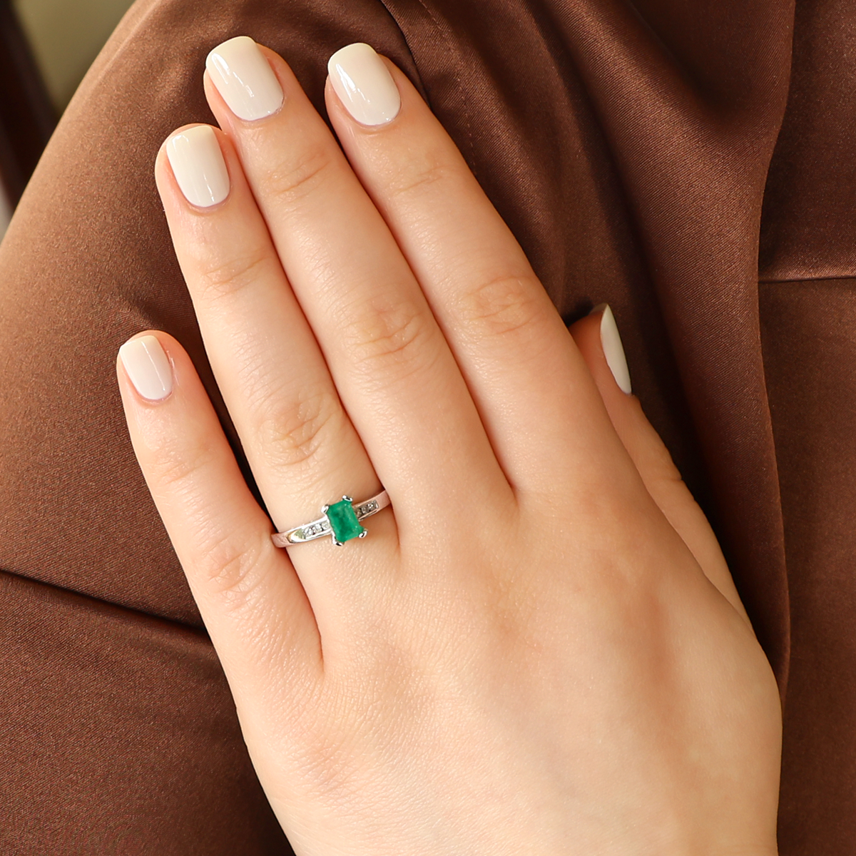 Model wears 18ct White Gold Emerald Cut Emerald & Diamond Solitaire Ring