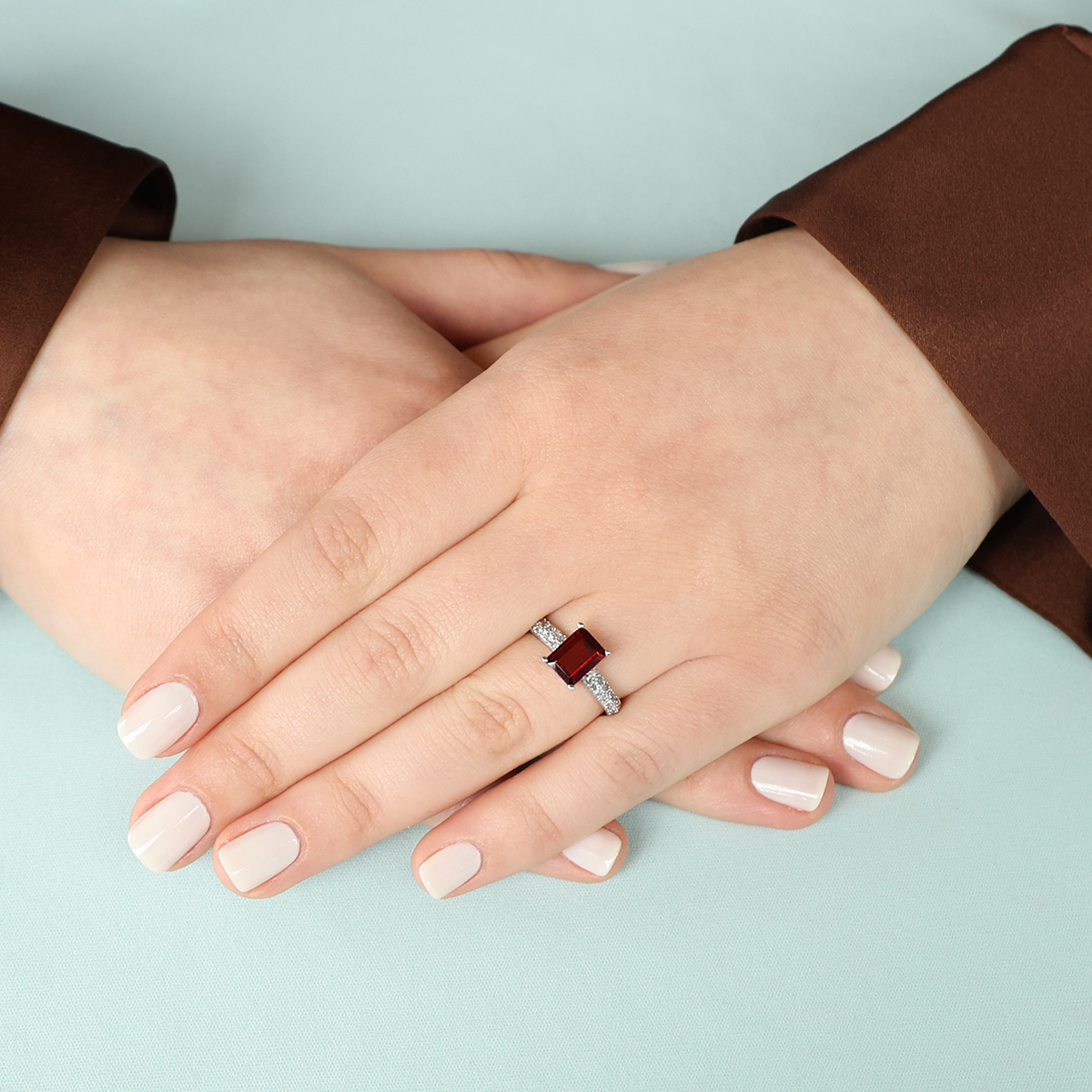 Model wears 9ct White Gold Emerald Cut Garnet Solitaire Ring With Diamond Shoulders