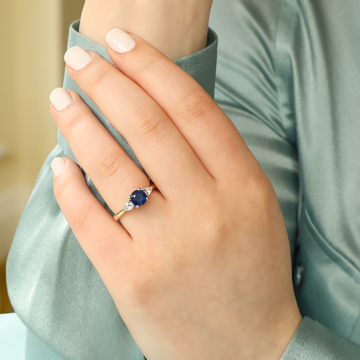 Model wears 18ct Yellow Gold Round Shaped Blue Sapphire & Diamond Trilogy Ring