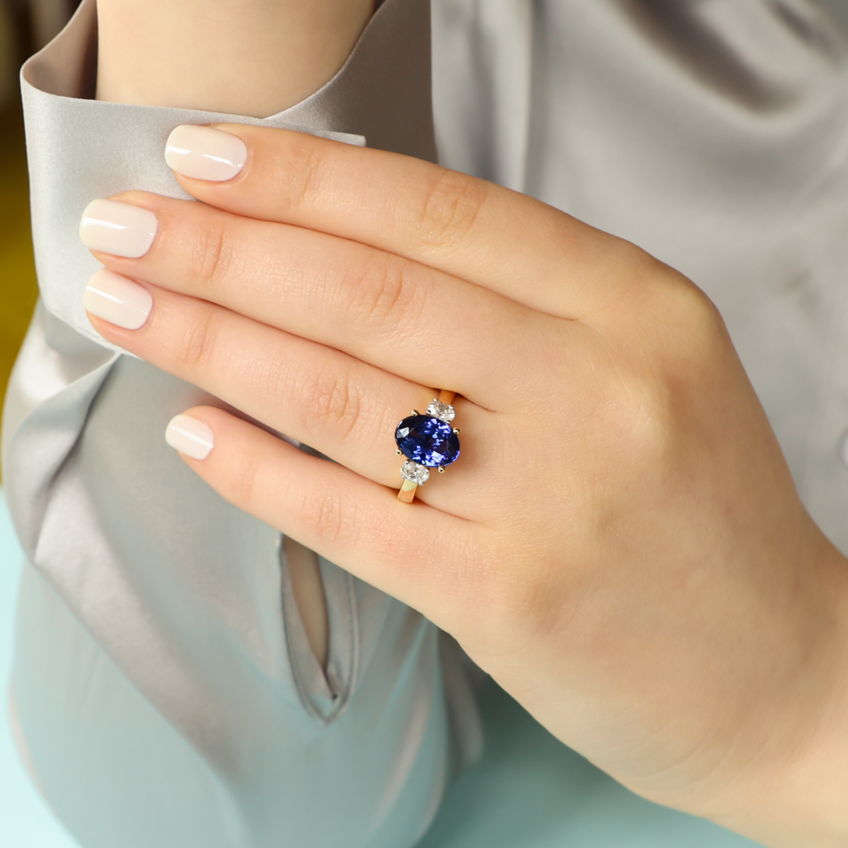 Model wears 18ct White Gold Oval Shaped Tanzanite & Diamond Trilogy Ring