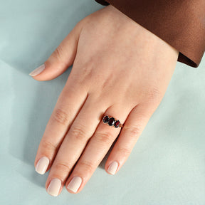 Model wears 9ct Yellow Gold Oval Shaped Garnet Trilogy Ring