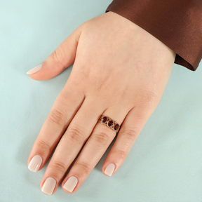 Model wears 9ct Yellow Gold Oval Shaped Garnet Trilogy Hearts Ring