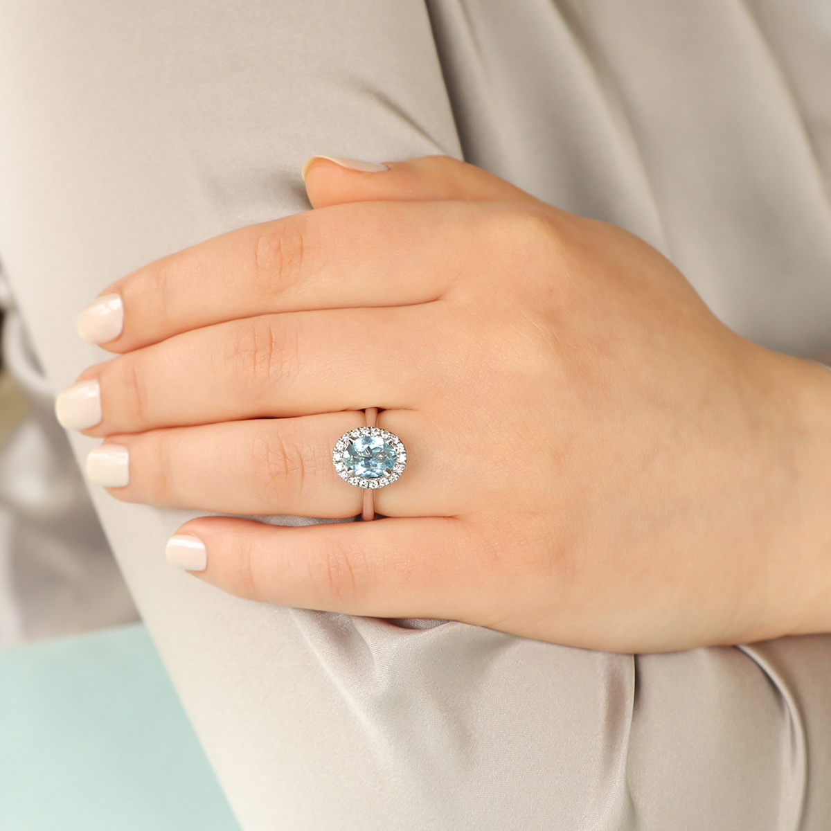 Model wears 18ct White Gold Oval Shaped Aquamarine & Diamond Cluster Ring