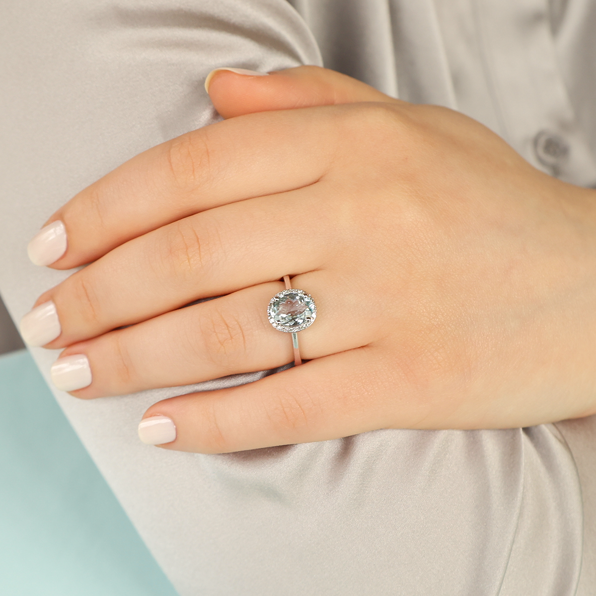 Model wears 9ct White Gold Oval Aquamarine & Diamond Cluster Ring