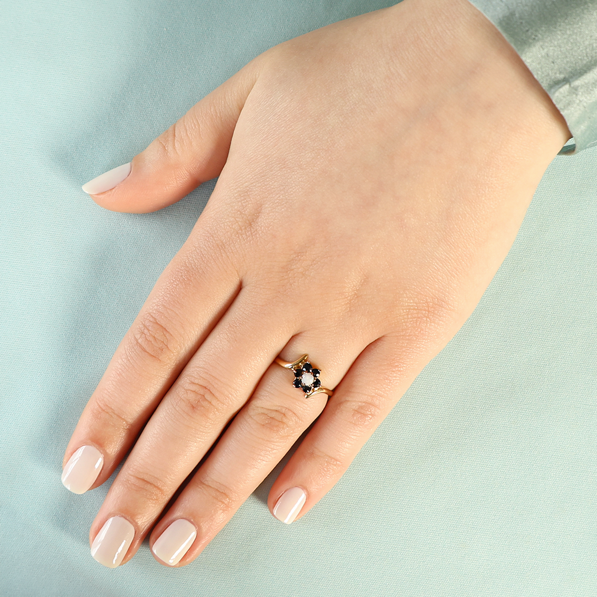 Model wears 9ct Yellow Gold Sapphire & Opal Flower Cluster Bypass Ring