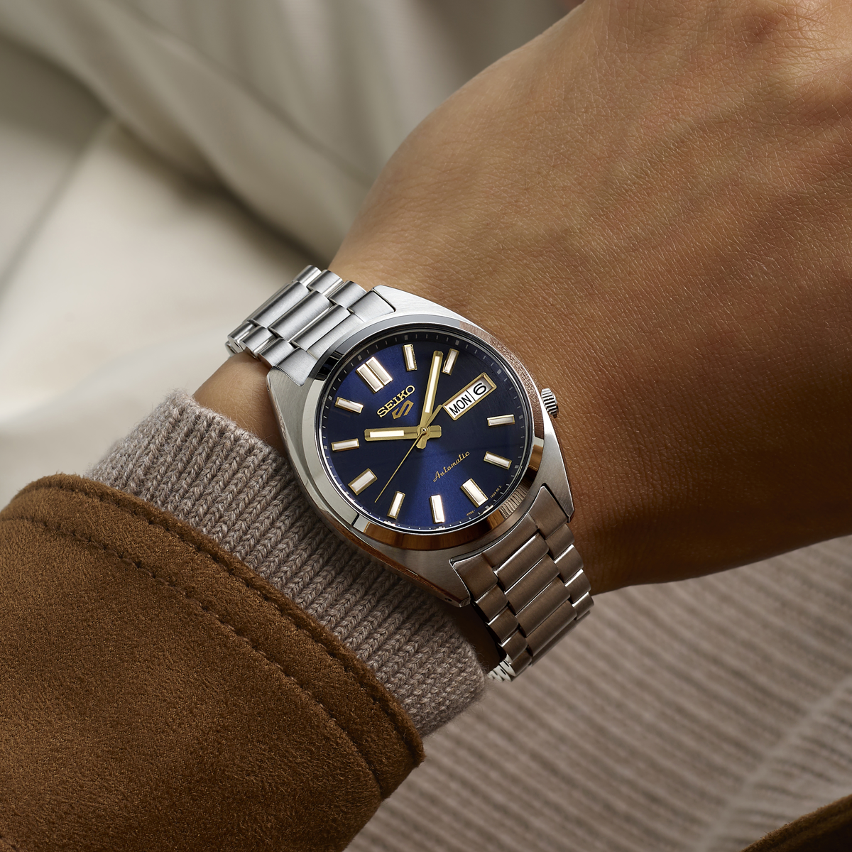 Model wears Seiko 5 Sports SNXS Vintage Gold Collection In Blazer Blue - SRPL55K1