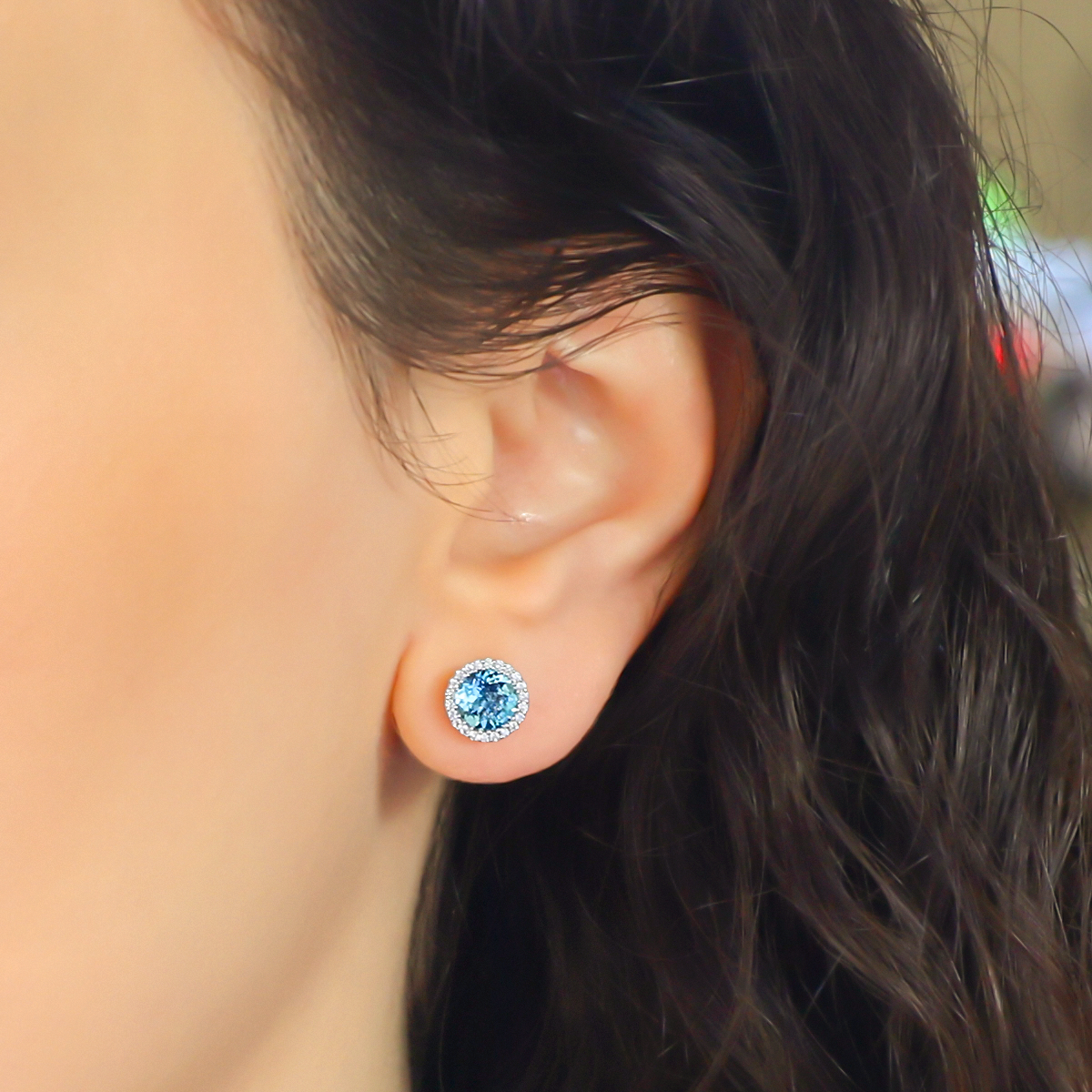 Model wears 18ct White Gold Blue Topaz & Diamond Round Halo Earrings