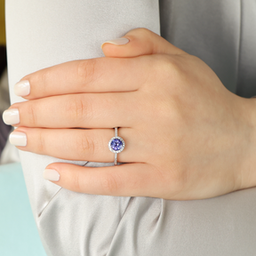 Model wears 18ct White Gold Tanzanite & Diamond Round Halo With Shoulders Ring