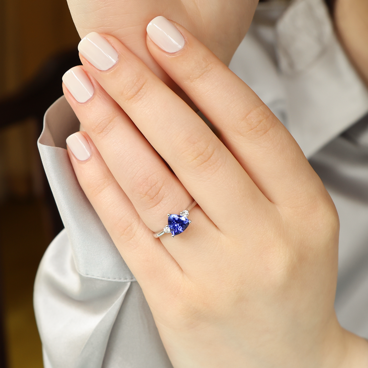Model wears 18ct White Gold Trilliant Cut Tanzanite & Diamond Trilogy Ring
