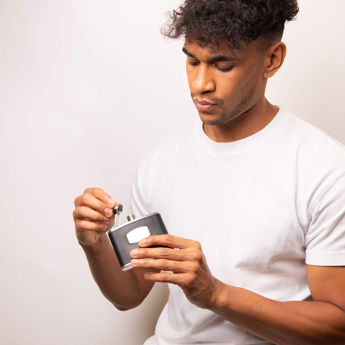 Model holding Fred Bennett Black Leather & Stainless Steel Hip Flask