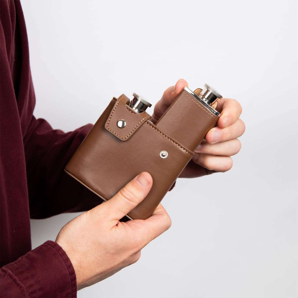 Model holds Stainless Steel & Brown Leather Twin 3oz Hip Flasks with Case