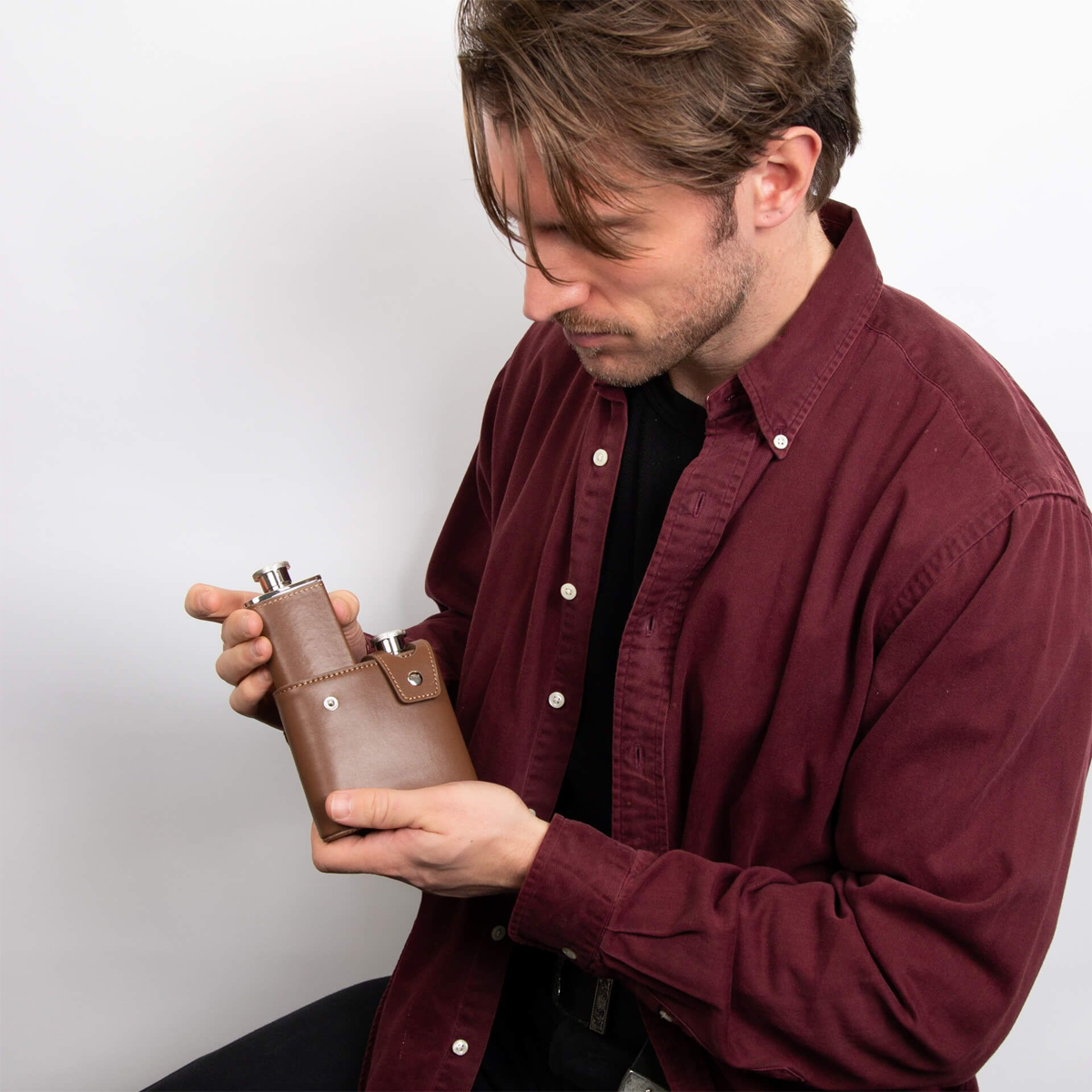 Model holds Stainless Steel & Brown Leather Twin 3oz Hip Flasks with Case