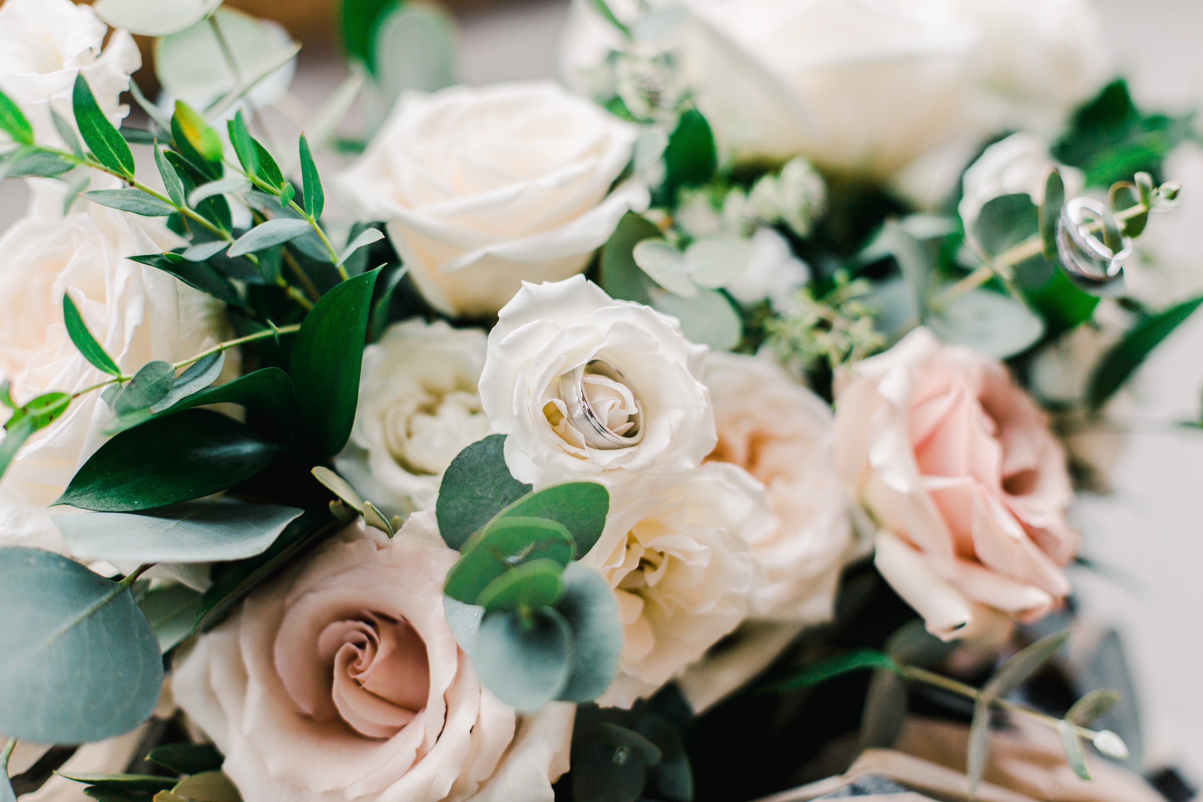 Wedding band embedded in a white rose flower. 