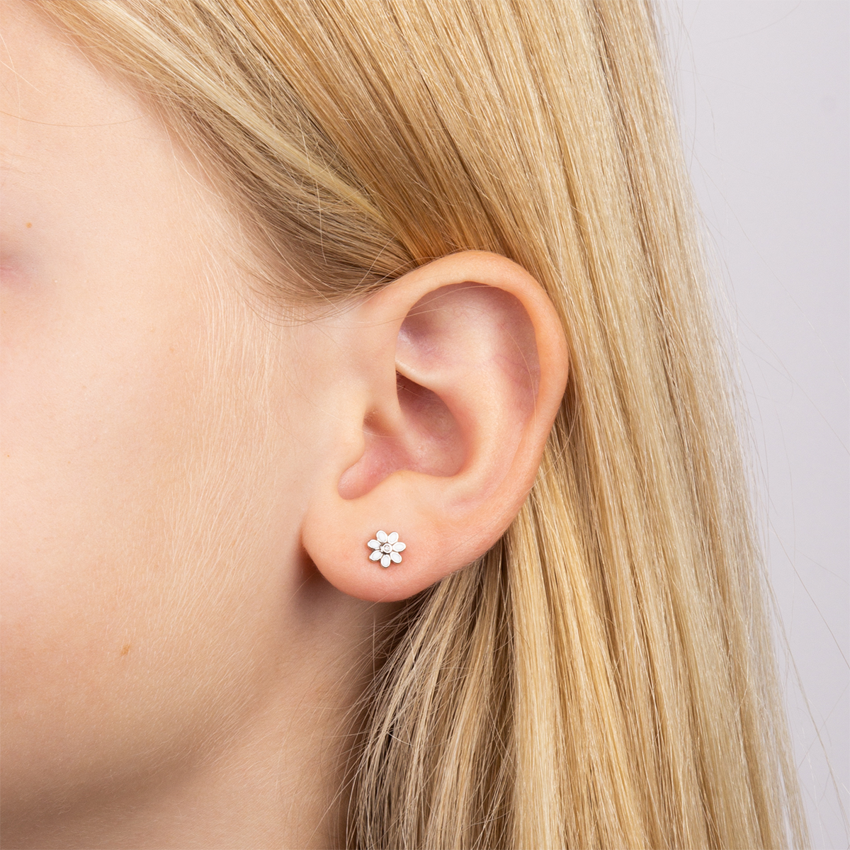 Model wears Sterling Silver White Enamel Daisy Stud Earrings With Diamond