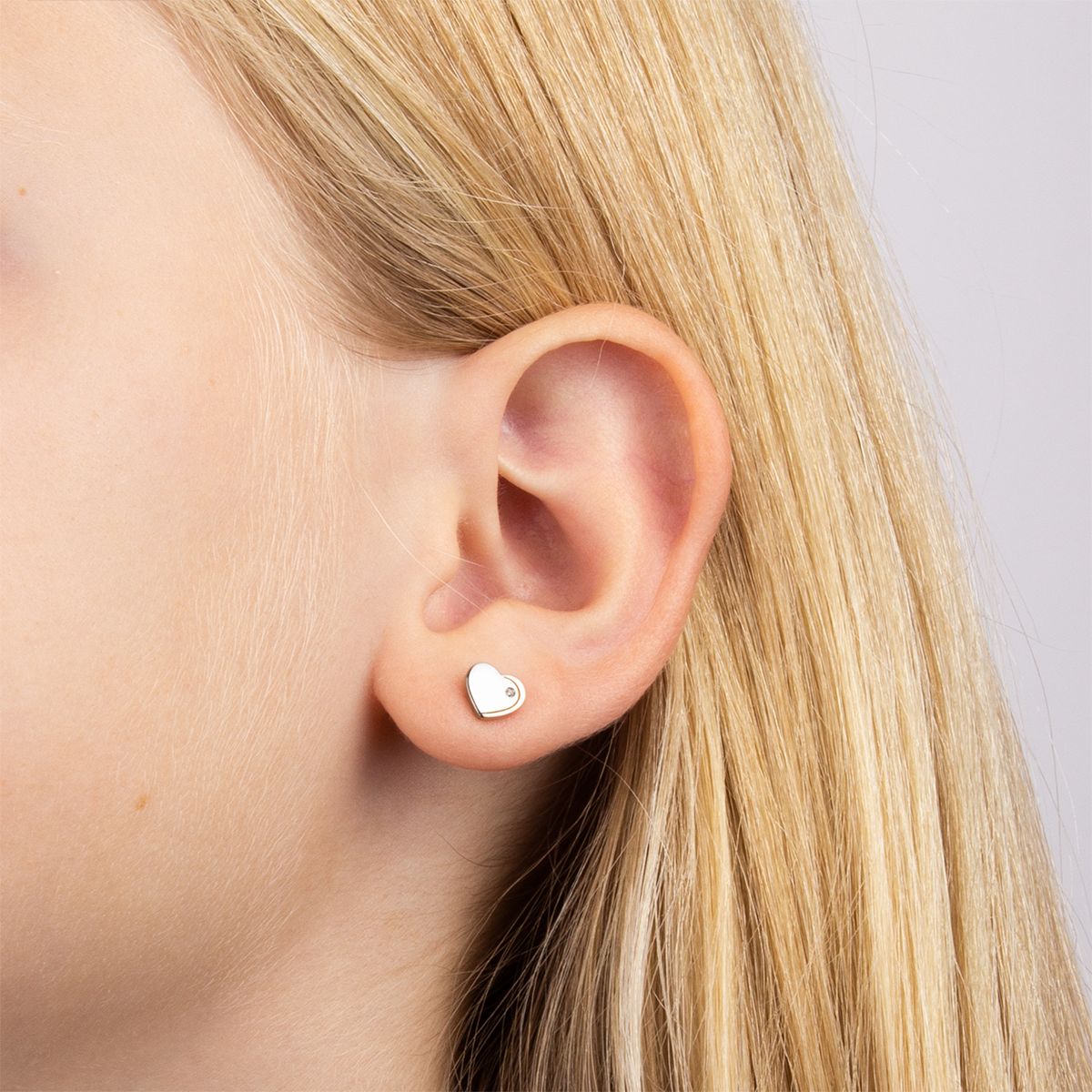 Model wears Recycled Sterling Silver Heart Stud Earrings with Rose Gold Plated Detail & Diamond