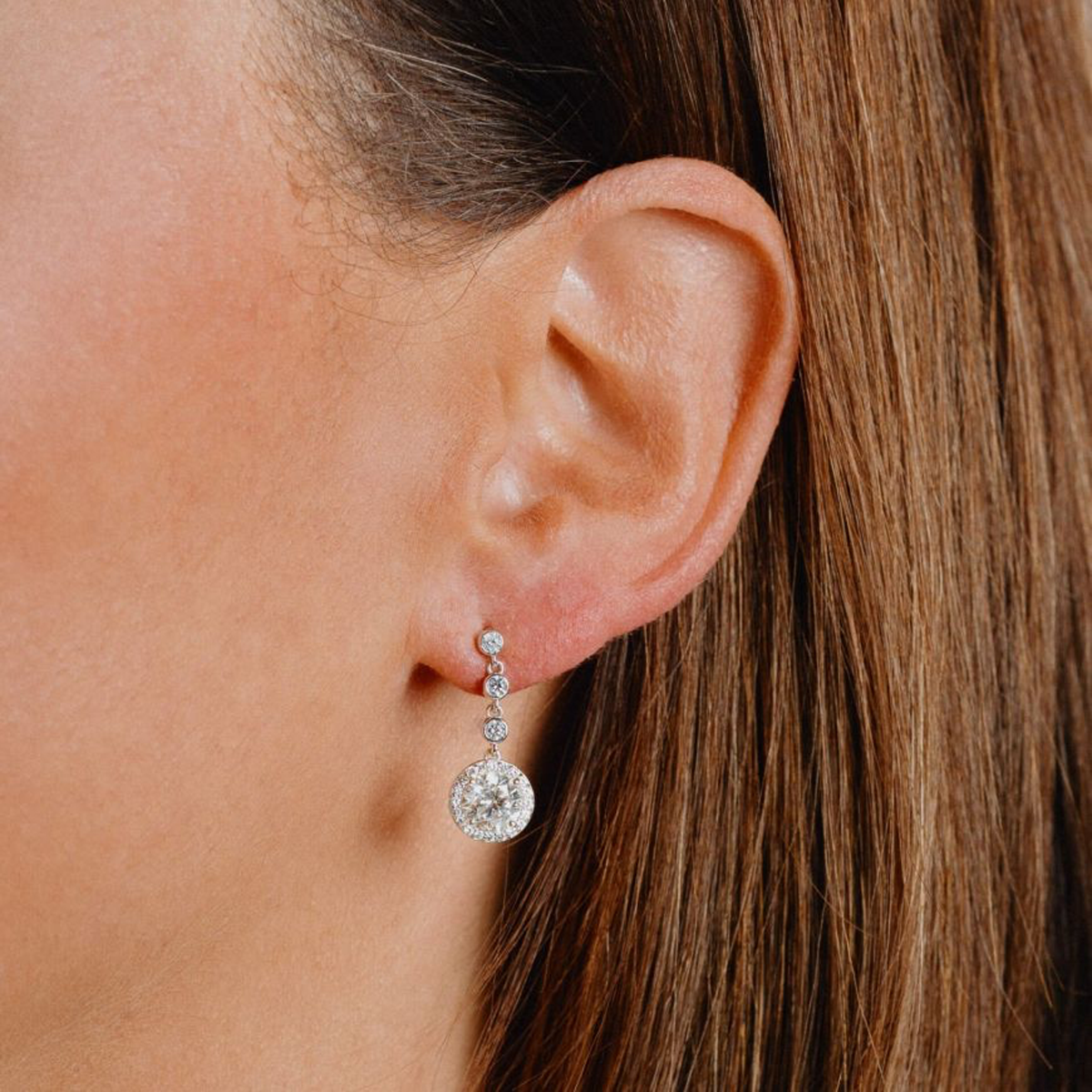 Models wears Sterling Silver Round Cubic Zirconia Halo Drop Earrings