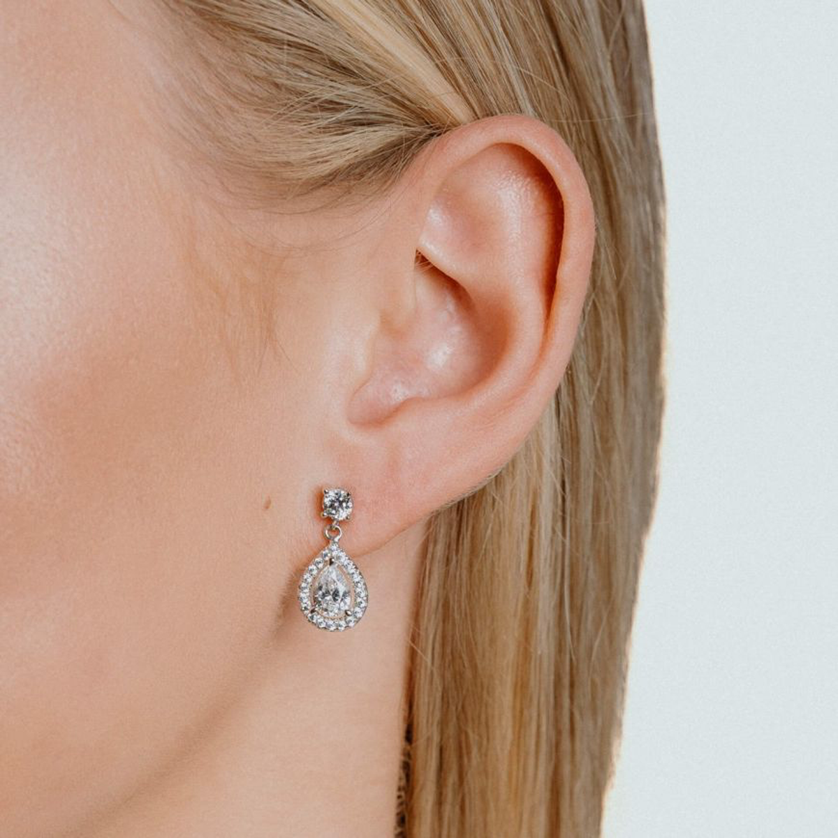 Models wears Sterling Silver Teardrop Cubic Zirconia Halo Drop Earrings