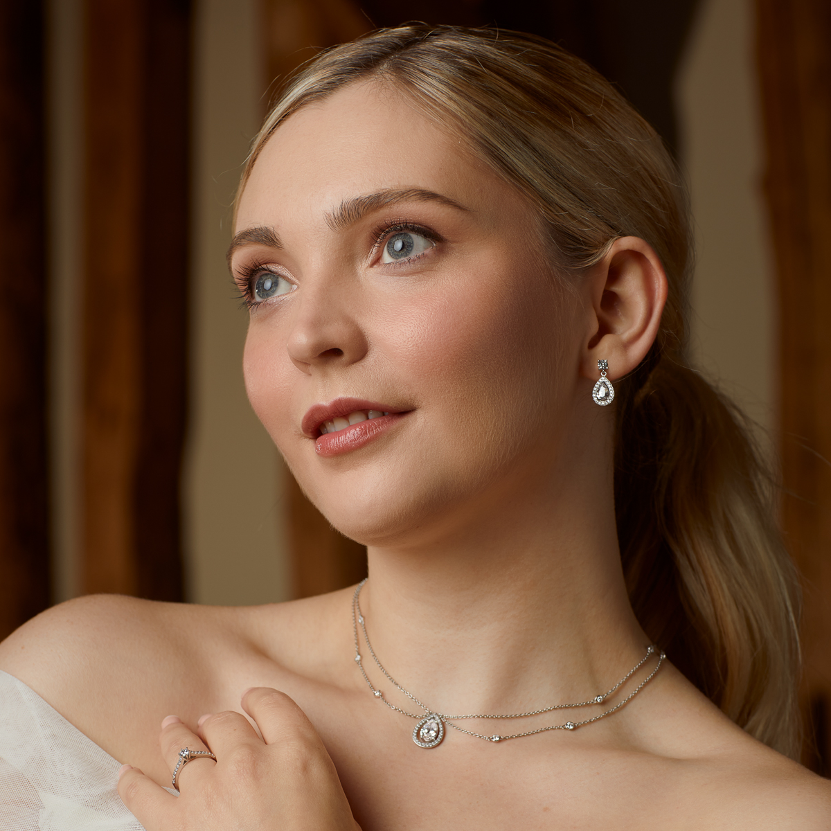 Model wears Sterling Silver Teardrop Cubic Zirconia Halo Earrings & Necklace