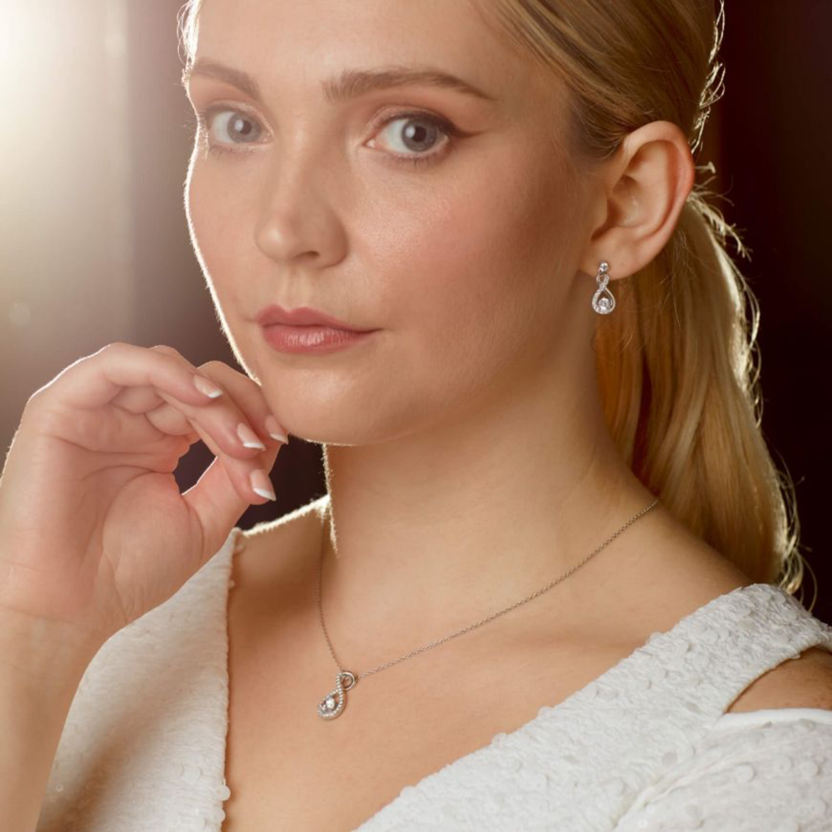 Model wears Sterling Silver Infinity Cubic Zirconia Set Pendant & Earrings