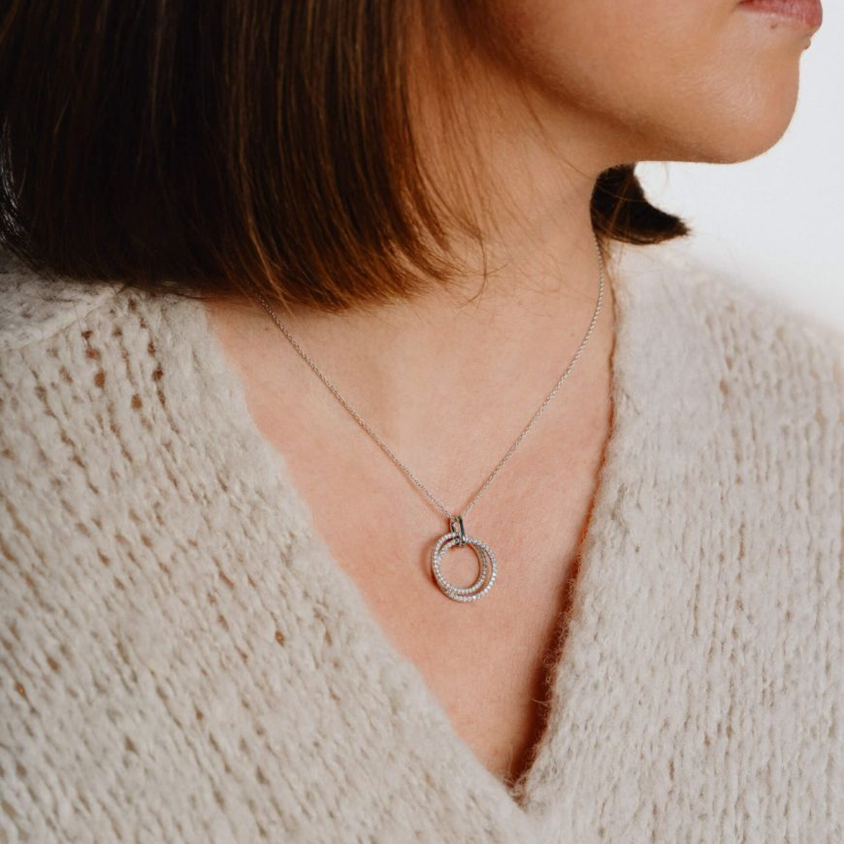 Model wears Sterling Silver Intertwined Circles Cubic Zirconia Set Pendant & Chain