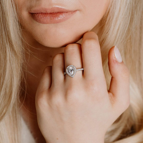 Model hand wearing Sterling Silver Teardrop Cubic Zirconia Halo and Shoulders Set Ring